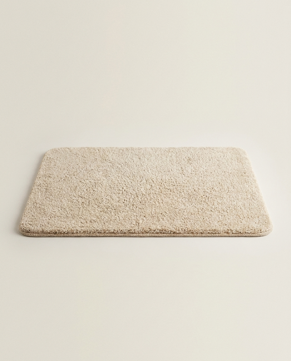 Plush non-slip bath mat on a clean light neutral studio background