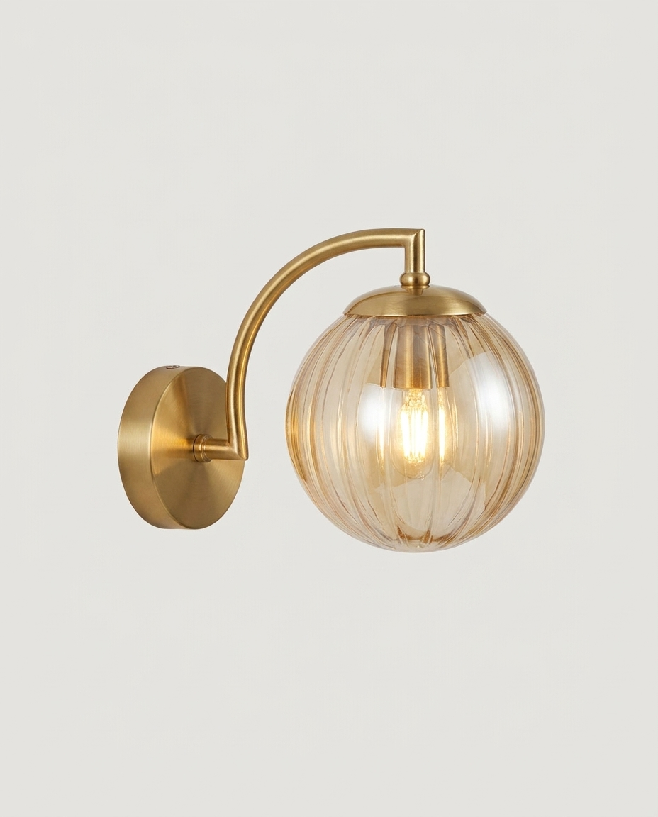 Gold-finish ribbed glass globe wall sconce on a clean light neutral studio background